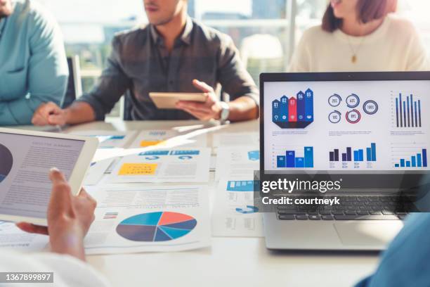 gruppe von menschen, die sich mit technologie und papierkram treffen. - man on chart stock-fotos und bilder