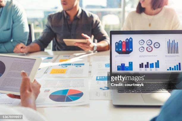 group of people meeting with technology and paperwork. - marketing stock pictures, royalty-free photos & images