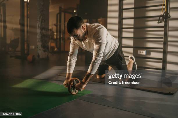 man training with roller wheel - training wheels imagens e fotografias de stock