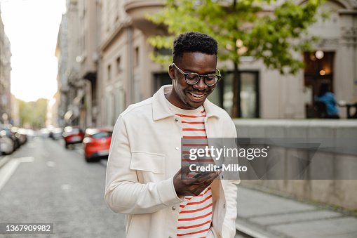 Young African-American man uses a mobile phone on the go Young African-American man uses a mobile phone on the go