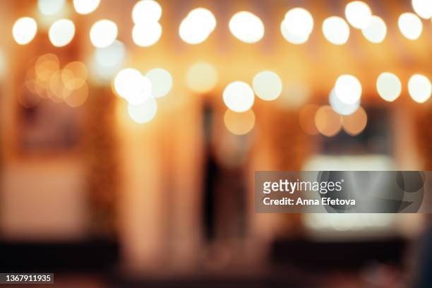 defocused exterior of a city cafe decorating with many festive lights. beautiful bright background for your design with copy space. front view - blurred motion restaurant stock pictures, royalty-free photos & images