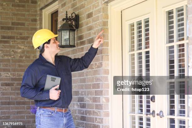latin descent man inspects home exterior. contractor, inspector. - inspector 個照片及圖片檔