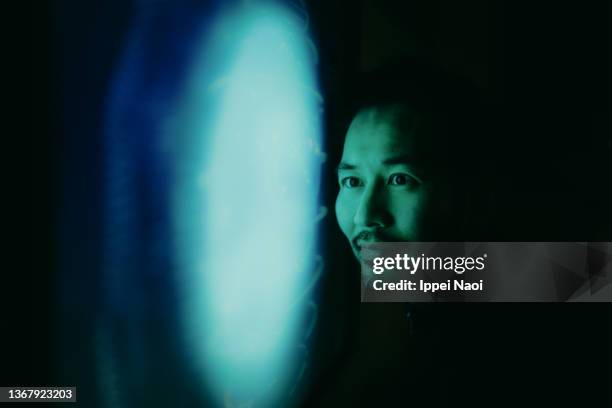 man looking at glowing planet on screen - glowing face stock pictures, royalty-free photos & images