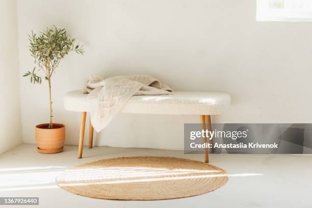 fluffy fur bench, wicker rug and olive plant in ceramic vase. - fur rug stock pictures, royalty-free photos & images