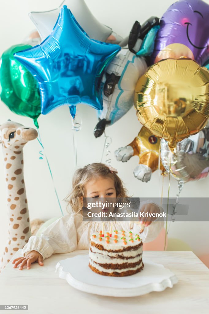 Young girl blowing candles for celebreating her 2th years birthday.