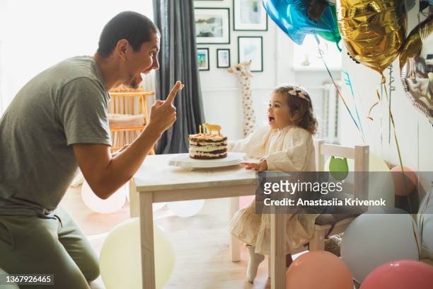 young girl with father eating cake and having fun for celebreating her 2th years birthday. - 2 3 years stock pictures, royalty-free photos & images