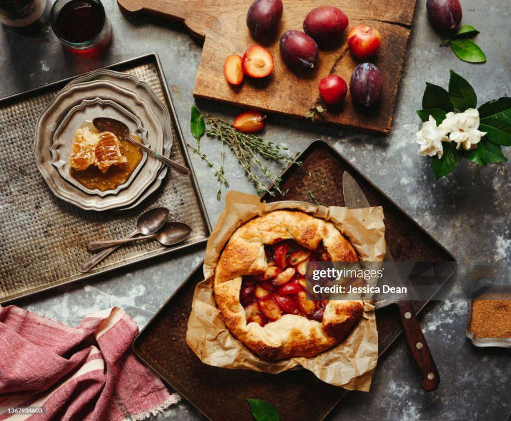 Plum and nectarine galette in elaborate, romantic scene.