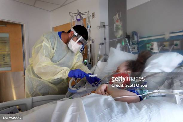 Respiratory Therapist Adel Al Joaid treats Melissa Wartman, a COVID-19 patient, in the ICU at Rush University Medial Center on January 31, 2022 in...