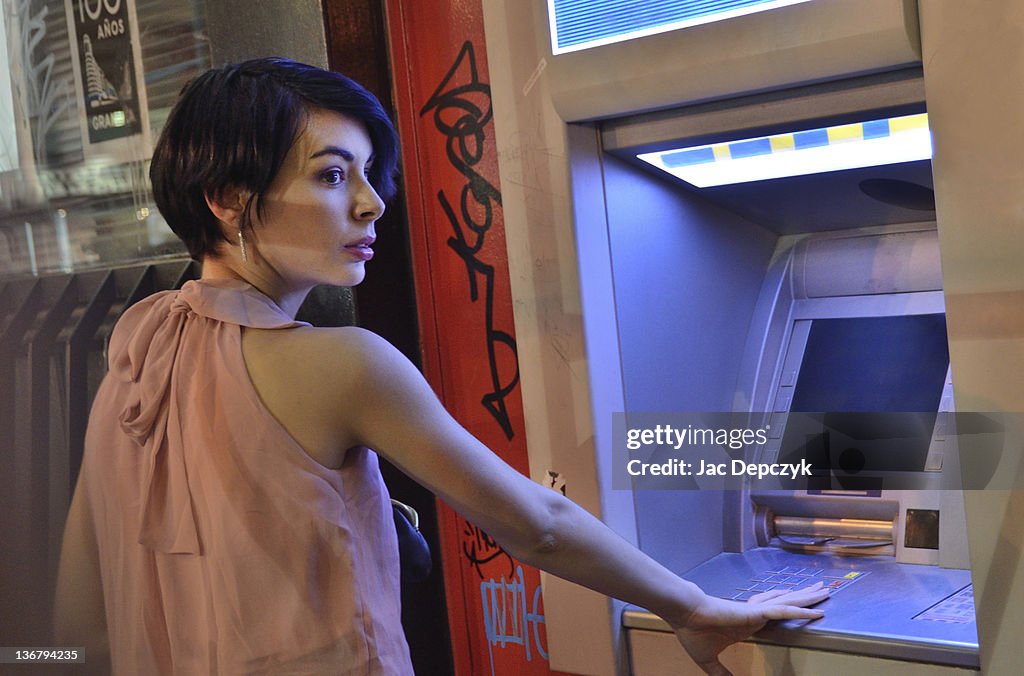 Young woman at cash dispenser terminal