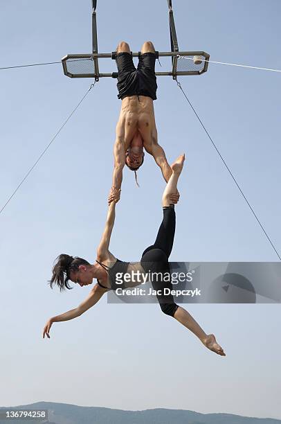 male and female acrobats perform high on trapeze - trapeze ストックフォトと画像