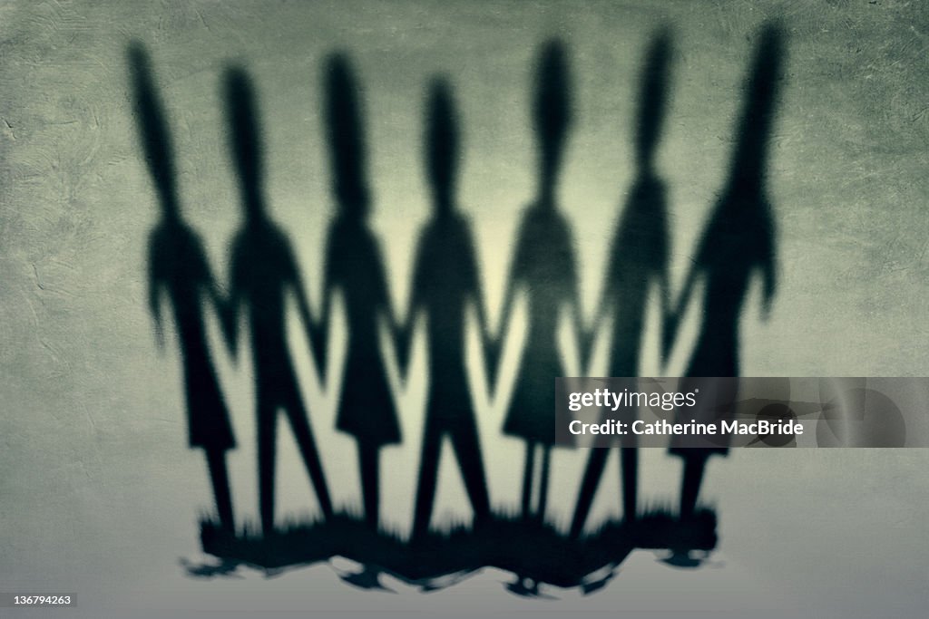Image of shadows cast from chain of paper people