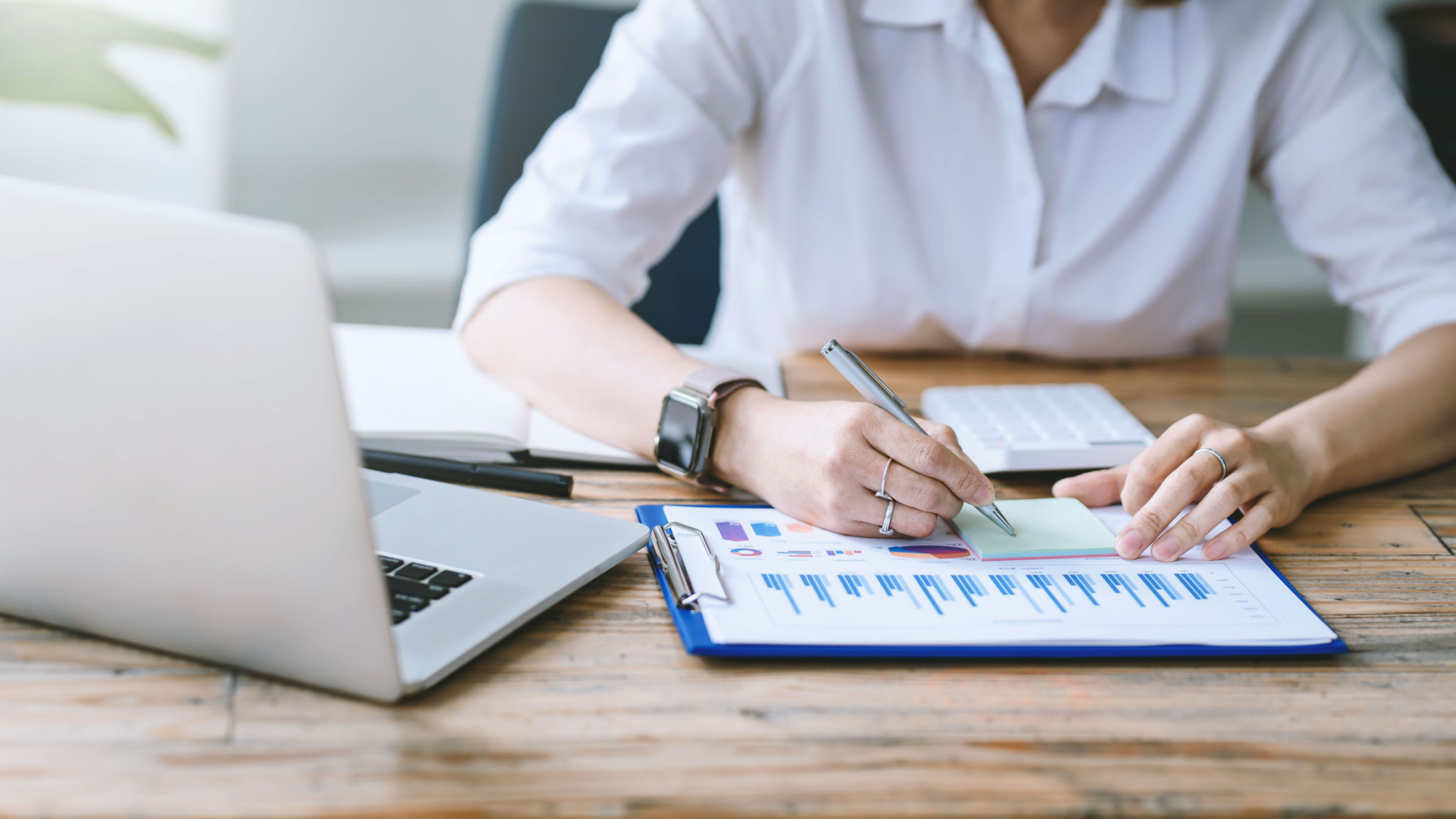 Close-up of businesswoman analyzing chart and graph showing changes on the market. Close-up of businesswoman analyzing chart and graph showing changes on the market.