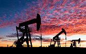 Oil pumpjacks in silhouette at sunset