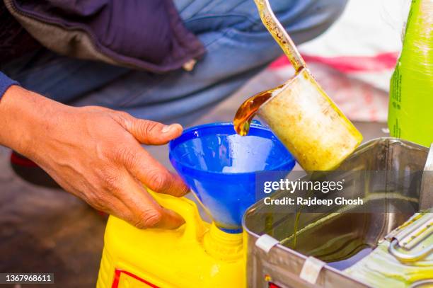 shopkeeper pouring edible oil for customer - mustard stock pictures, royalty-free photos & images