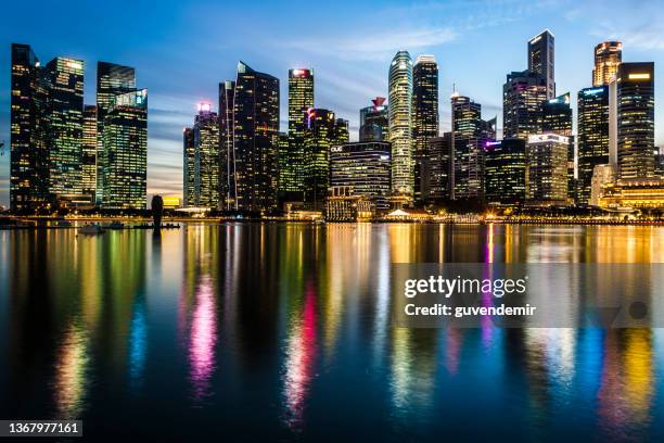 skyline von singapur in der dämmerung - riverbank stock-fotos und bilder