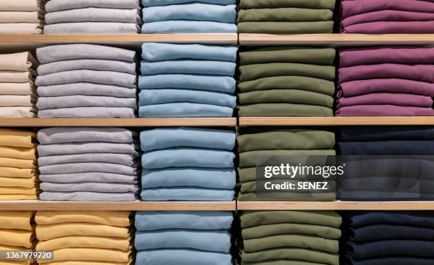 stack of clothes for sale in store - kledingwinkel stockfoto's en -beelden
