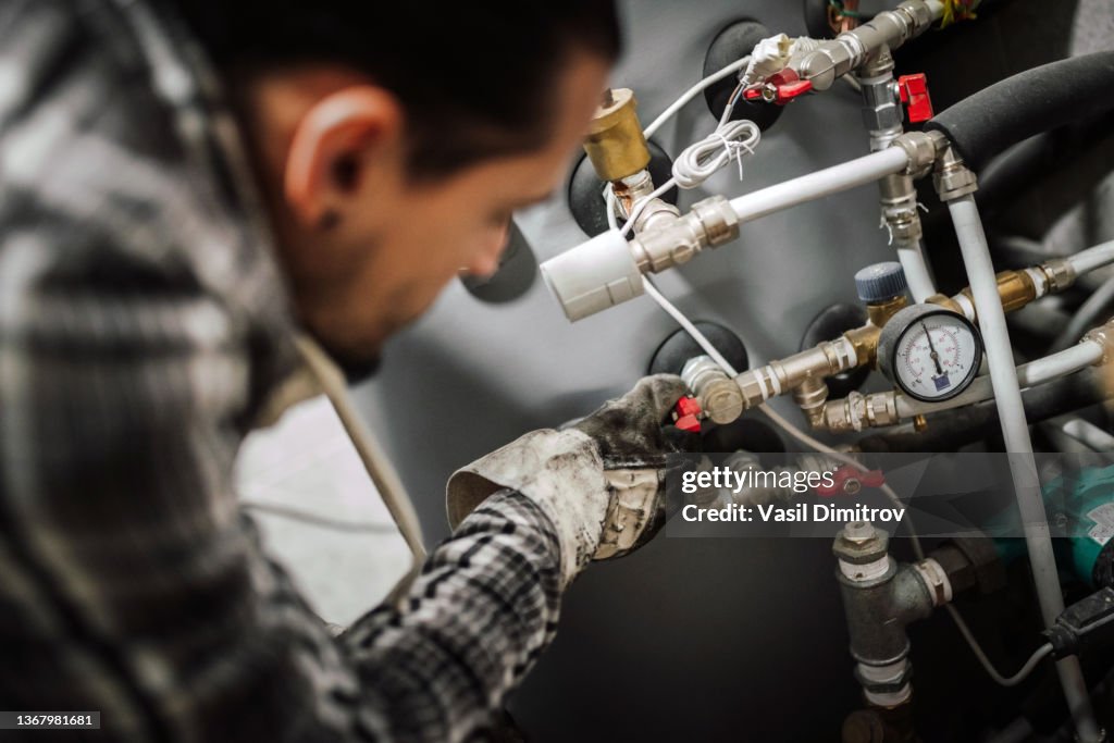 Heating engineer fixing modern heating system.