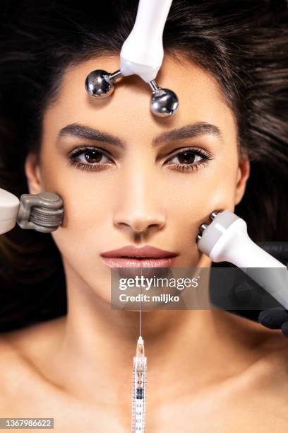 portrait of young woman receiving full beauty treatment - facial massage stock pictures, royalty-free photos & images