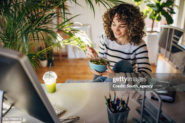 woman eating a salad in office - woman salad stockfoto's en -beelden