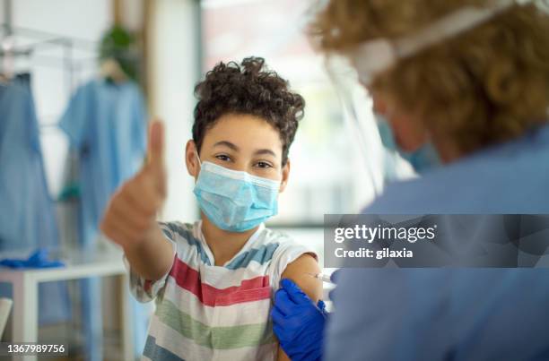 little boy receiving covid-19 vaccine. - protective face mask happy stock pictures, royalty-free photos & images