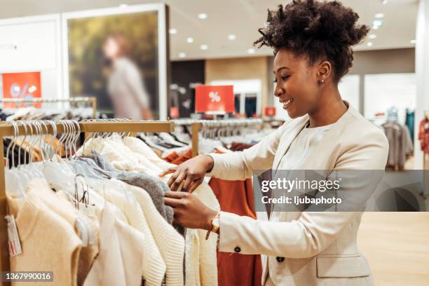 tiro de uma jovem olhando para alguns itens em uma boutique - loja de roupas - fotografias e filmes do acervo