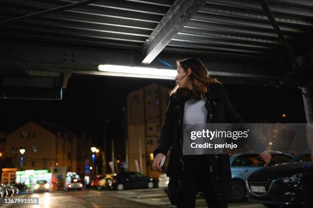 adolescente caucasienne inquiète, courant sur le parking tout en regardant par-dessus l’épaule - regarder par dessus son épaule photos et images de collection