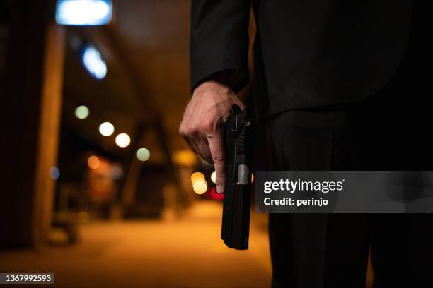 unrecognizable man holding the gun - pistool handwapen stockfoto's en -beelden