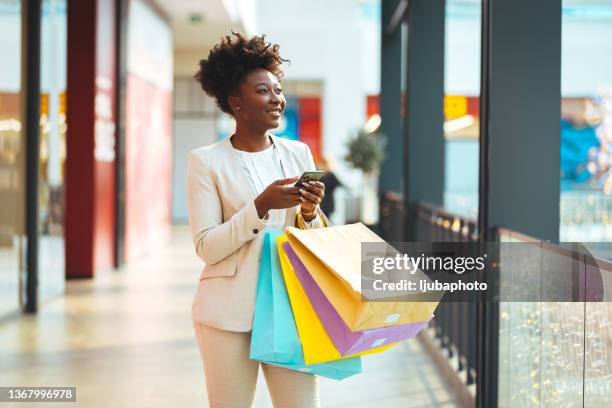 photo d’une jeune femme utilisant son smartphone pour passer un appel - african woman shopping photos et images de collection