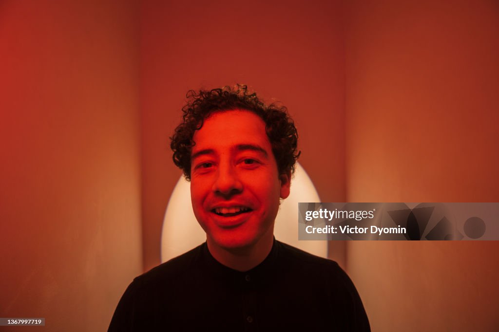Indoor portrait of the happy curly man