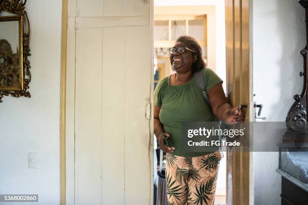 senior woman opening the hotel room door - entering atmosphere stock pictures, royalty-free photos & images