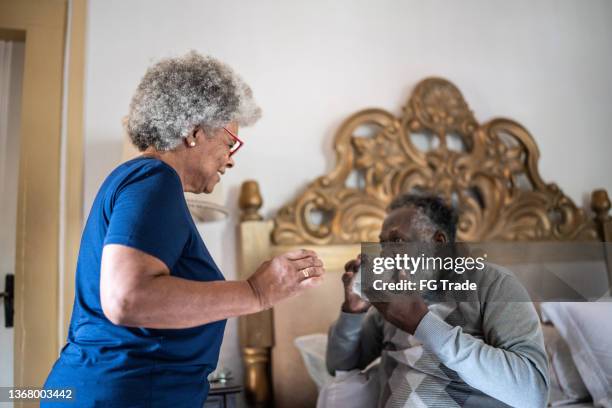 mujer que le da medicamentos a su esposo por la mañana - african american man helping elderly fotografías e imágenes de stock