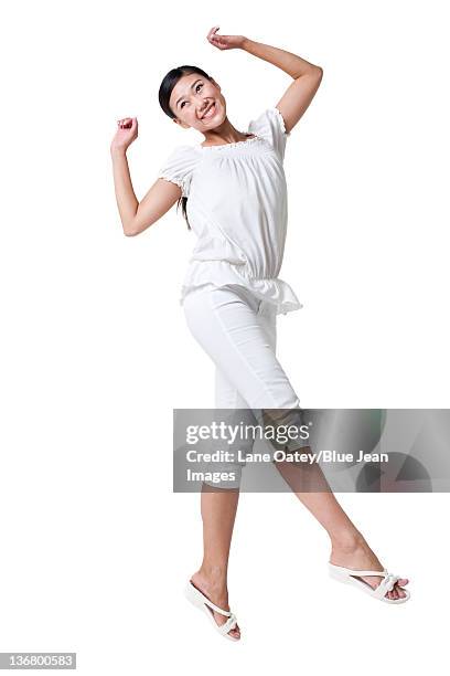 young woman jumping in the air - short sleeved stockfoto's en -beelden