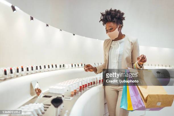 jeune femme séduisante faisant ses courses dans un magasin de cosmétiques - duty free photos et images de collection