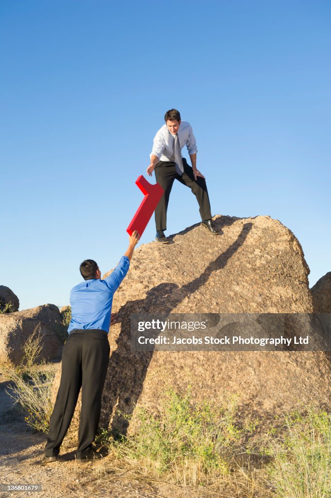 Businessman handing large number 1 to co-worker