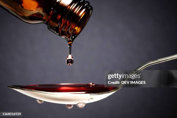 pouring medication or antipyretic syrup into spoon - syrup stock pictures, royalty-free photos & images