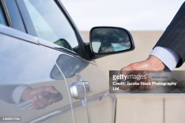 hispanic businessman using electronic key to open car door - auto mieten stock-fotos und bilder