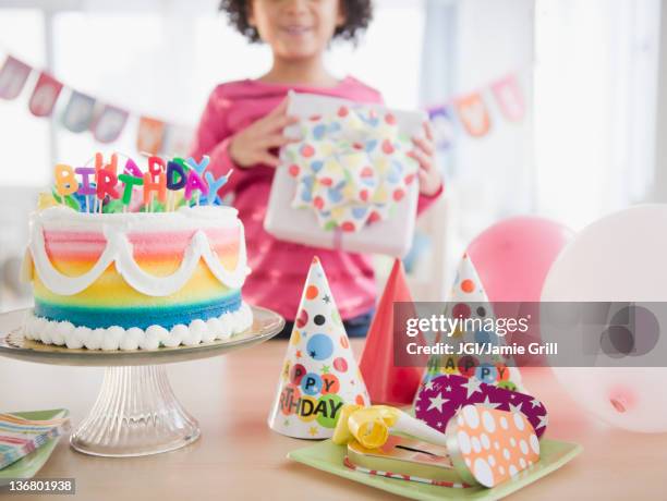 african american girl holding gift at birthday party - birthday gift stock pictures, royalty-free photos & images