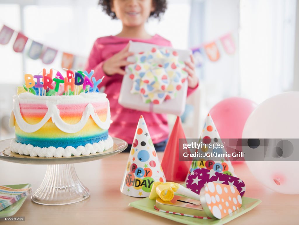 African American girl holding gift at birthday party