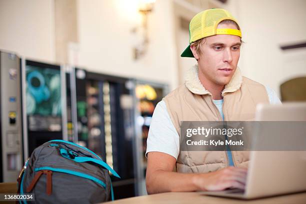 caucasian man using laptop in train station - leaning back stock pictures, royalty-free photos & images