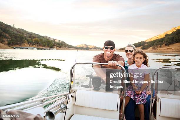 girl and parents enjoying riding on boat - steering boat stock pictures, royalty-free photos & images