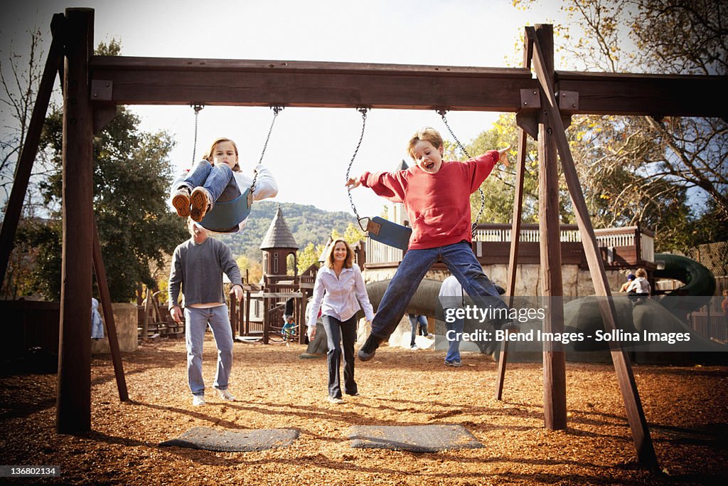 Parents watching children swinging