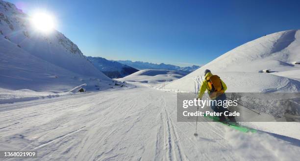 lone man skiing on empty mountain - wintersport stock-fotos und bilder