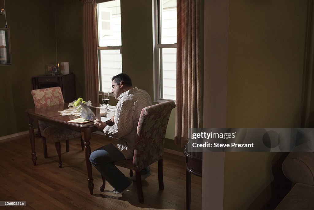 Caucasian man having dinner and reading