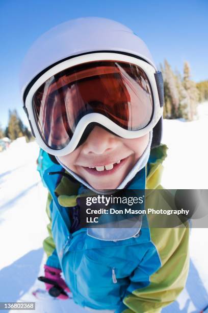 grinning mixed race girl wearing helmet and goggles - funny snow skiing fotografías e imágenes de stock