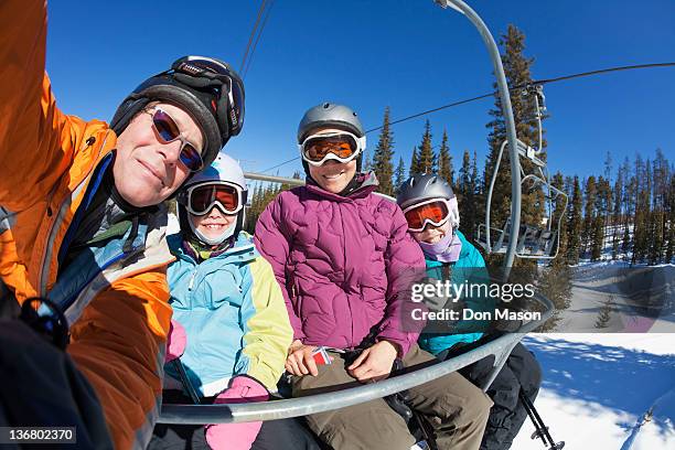 family riding ski lift together - woman on ski lift stock pictures, royalty-free photos & images