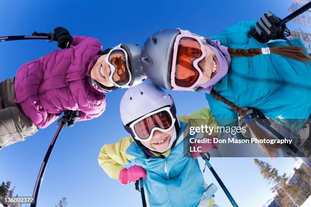 grinning family skiing together - family winter sport stock pictures, royalty-free photos & images