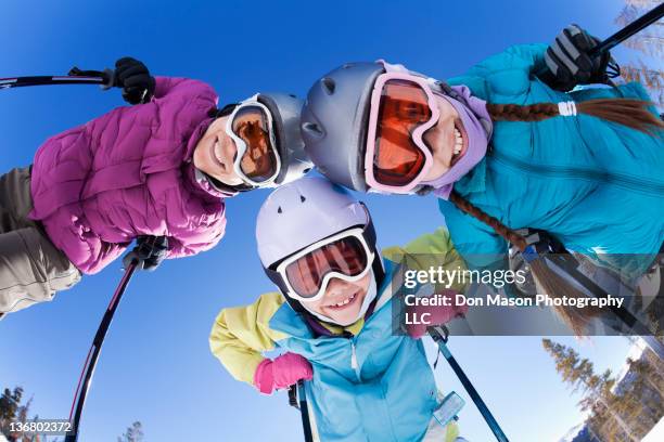 grinning family skiing together - kid looking up to the sky imagens e fotografias de stock