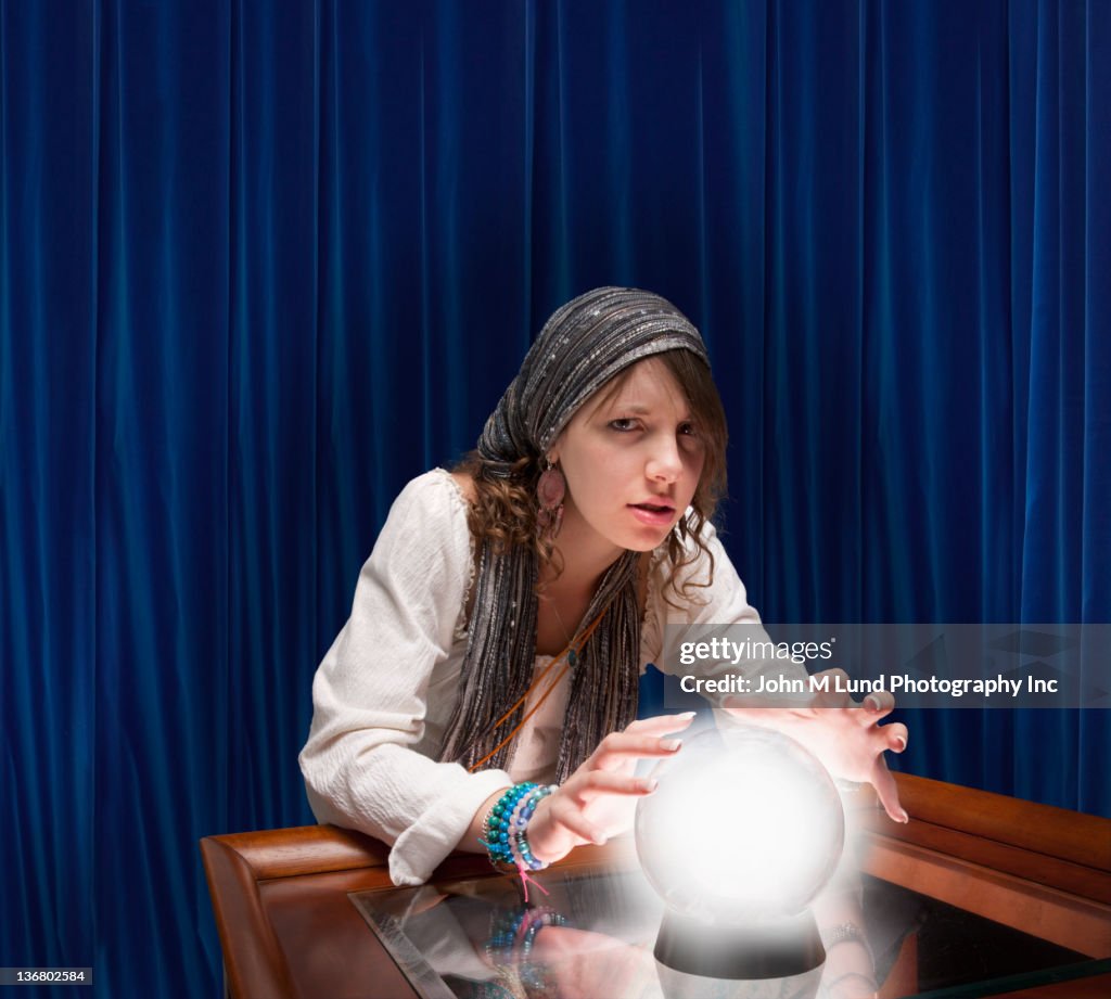 Mixed race fortune teller with crystal ball