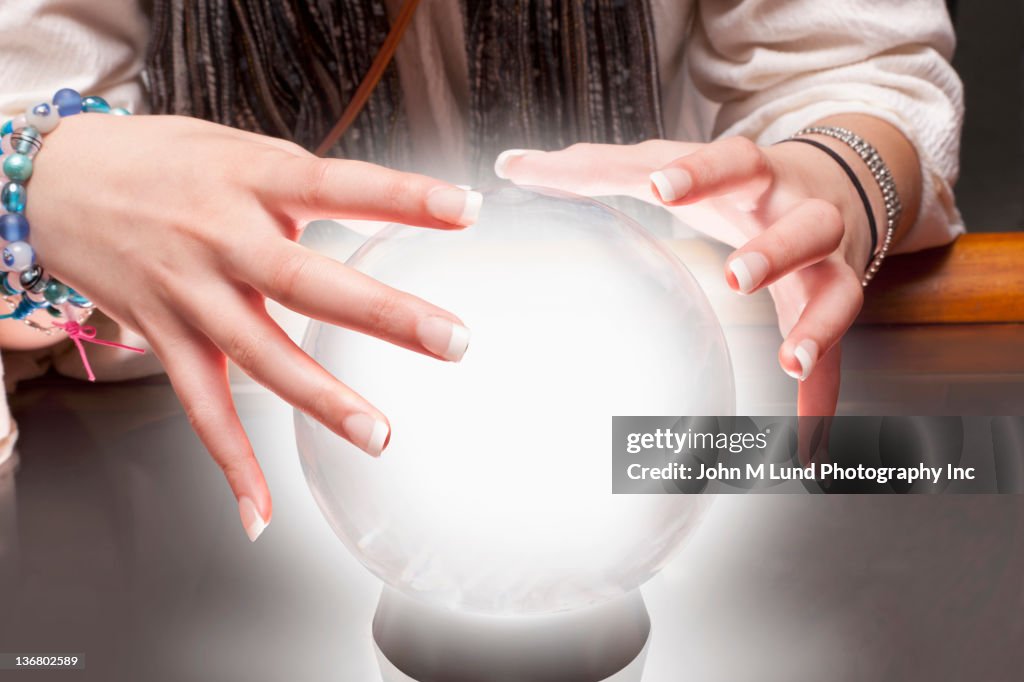 Mixed race fortune teller with crystal ball