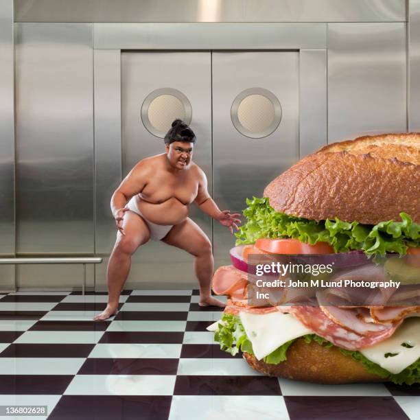 sumo wrestler next to large sandwich - american sumo stock-fotos und bilder